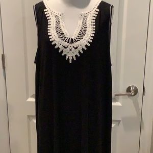 Woman’s black sleeveless tank dress with cream colored embroidery around V neck